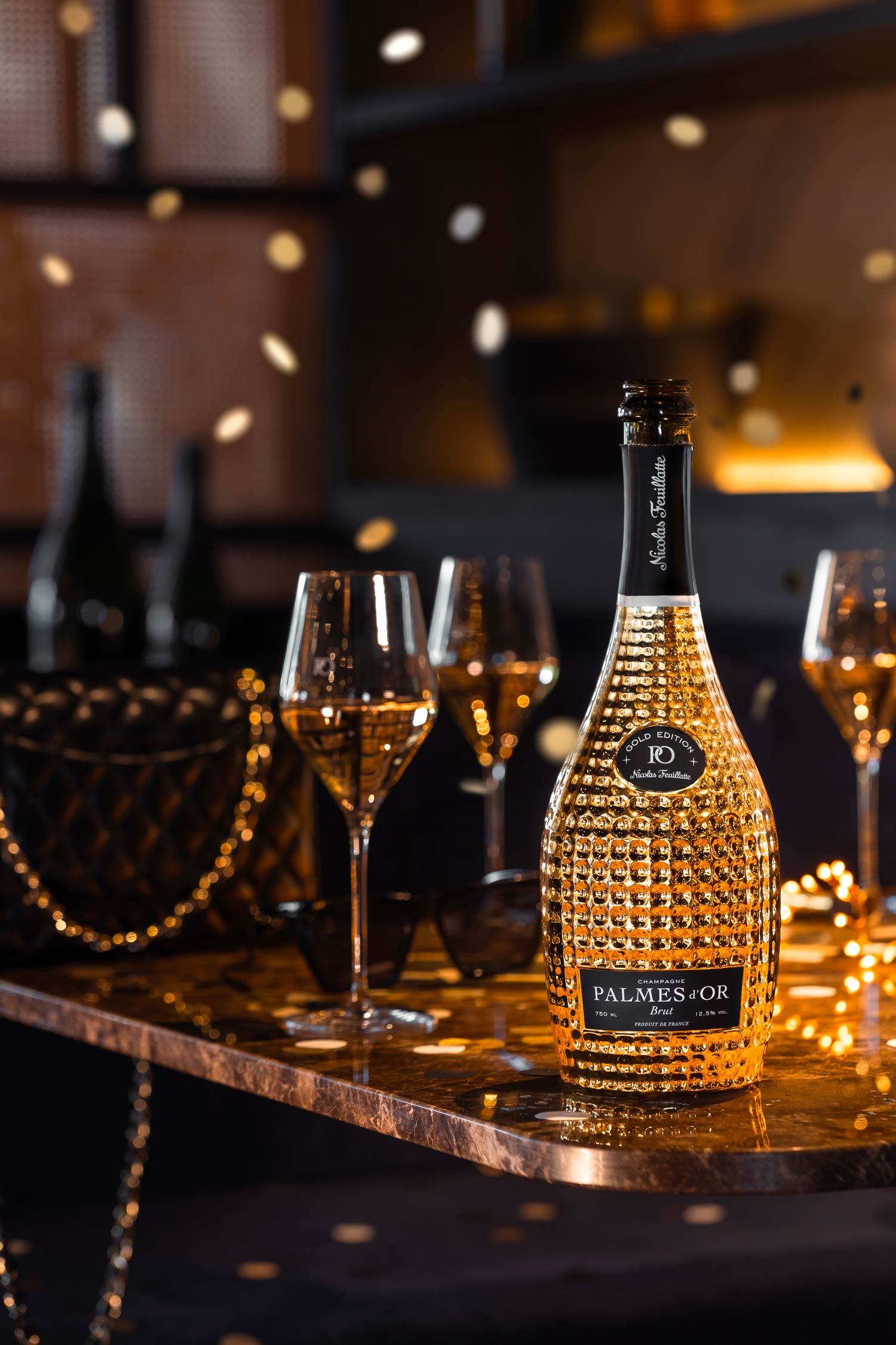 Bouteille de Champagne Palmes d'Or Gold posée sur une table dans un club | Réalisation Agence Discovery